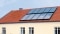 La foto muestra paneles solares en el tejado como apoyo a la calefacción.