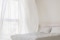 La imagen muestra un dormitorio con una ventana abierta y cortinas ondulantes.